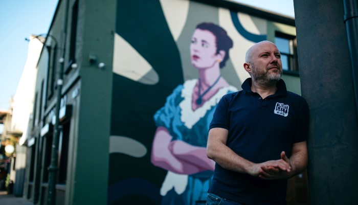 Man standing in front mural in Limerick